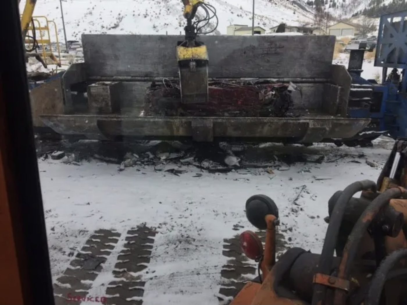 Crusher loading a flattened car